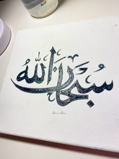 an arabic calligraphy is displayed on a table