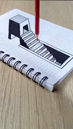 a spiral notebook with a drawing of a stair case on the cover and a pencil sticking out of it