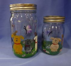 two glass jars with animals painted on them, one has a dog and the other is a sheep
