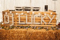 a sign made out of wooden pallets sitting on top of hay