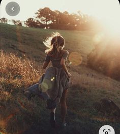 a woman in a dress walking up a hill