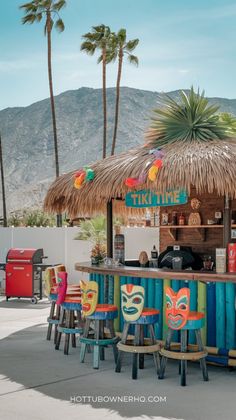 colorful tiki bar with tiki masks on the stools and thatched roof