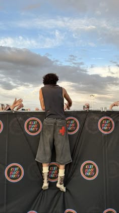 a man standing on top of a stage with his hands in the air while holding onto a frisbee
