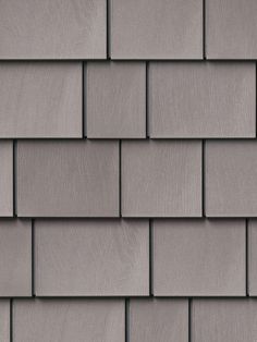 a close up view of a gray shingled roof with dark woodgrains on it