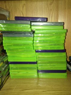 a stack of green plastic containers sitting on top of a wooden table