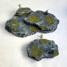 three pieces of rock with moss growing on them