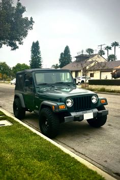 a green jeep is parked on the street