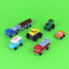 small toy cars are arranged on a green background