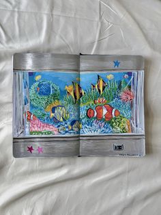 an open book with pictures of fish and sea creatures in it on a white sheet