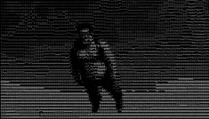 a black and white photo of a person standing in front of a wall with text on it