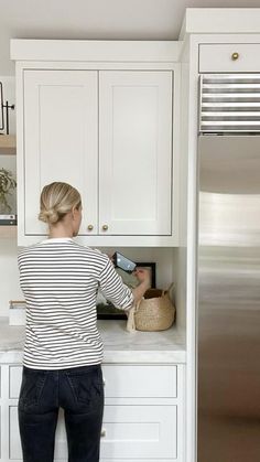 a woman standing in front of a refrigerator