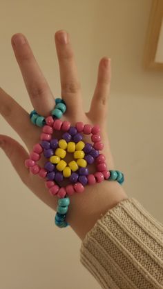 a person's hand with colorful beads on it