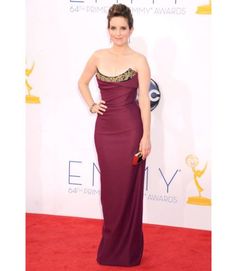 a woman in a purple dress on the red carpet at an awards event with her hand on her hip