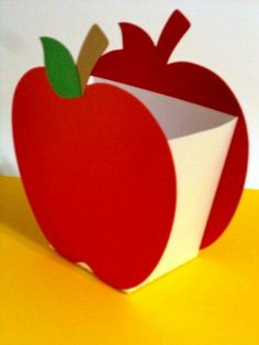 an apple shaped box sitting on top of a yellow table