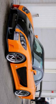 an orange sports car parked in a garage