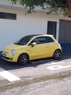 a small yellow car parked in front of a building