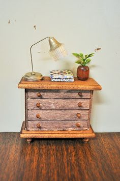 a small wooden dresser with a lamp on top