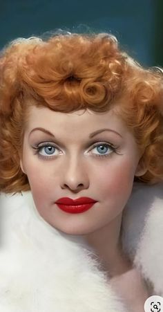 a woman with red hair and blue eyes is wearing white fur collared coat, posing for the camera