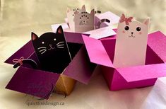 three small boxes with cats in them sitting on a table