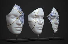 three white masks with blue and gold designs on their faces are shown in front of a black background