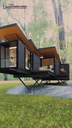 a house made out of shipping containers sitting on top of a lush green field with trees in the background