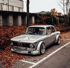 an old bmw is parked on the side of the road
