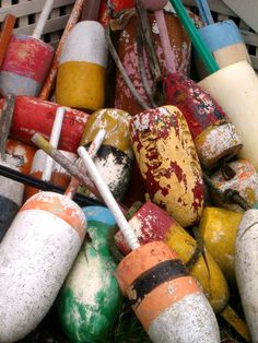 there are many different colored buoys in the basket and one has a white stick sticking out of it