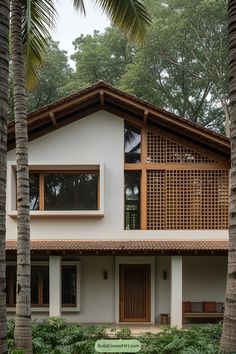 a white house surrounded by palm trees and greenery