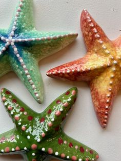 three starfishs are sitting on a white surface
