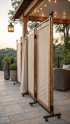 an outdoor room with patio furniture and string lights on the ceiling, along with two privacy screens that are open to let in natural light