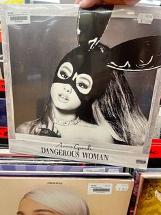 a person holding up a cd cover with a cat mask on it's face