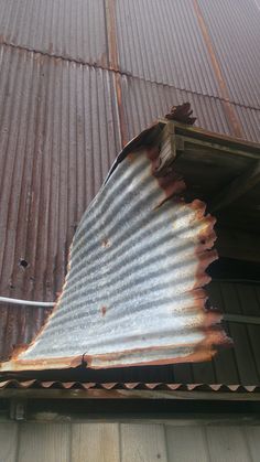 an old corrugated roof with rusted metal sheets on the top and bottom part missing