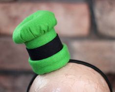 a man with a green hat on top of his head and a black band around it