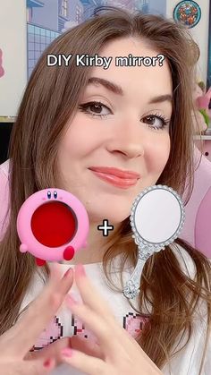 a woman holding a mirror and looking at it with the caption diy kitty mirror?