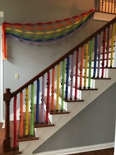 a stair case with colorful ribbons hanging from it's sides and on the wall