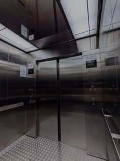 an elevator with stainless steel doors and checkered flooring
