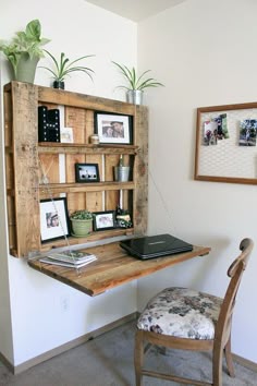 a wooden desk topped with a laptop computer next to a wall mounted book shelf filled with pictures
