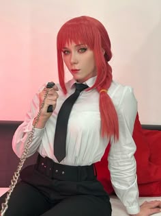 a woman with red hair sitting on a bed holding a cell phone in her hand