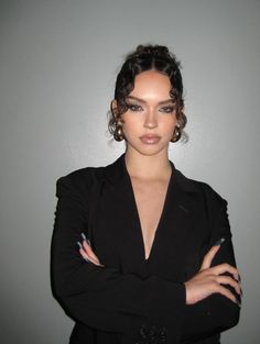 a woman with her arms crossed posing for the camera