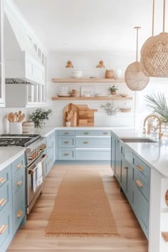 a kitchen with blue cabinets and wooden floors, white walls and shelves above the stove