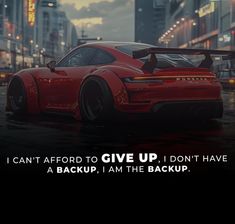 a red sports car parked in the middle of a city street with an inspirational quote above it