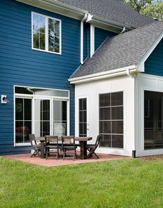a blue house with a table and chairs outside
