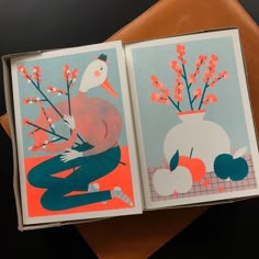 an open book with two pictures of flowers in vases
