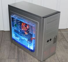 a computer case with an aquarium inside it on the floor in front of a white wall