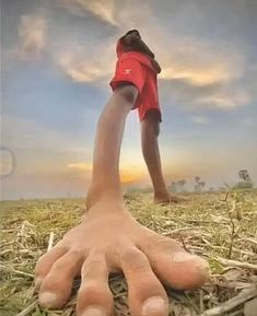 a person standing in the middle of a field with their hands extended out to grab something