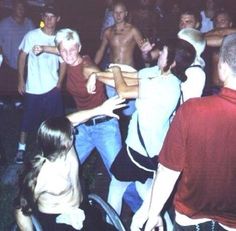 a group of people dancing around each other in a room full of people with no shirts on