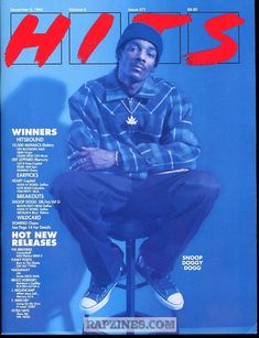 a man sitting on top of a stool in front of a blue wall with the words hots