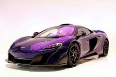 a purple and black sports car sitting on top of a white floor