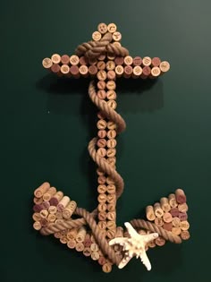 a cross made out of wine corks on a green wall with a starfish