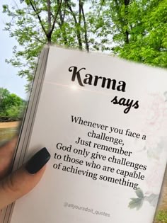 someone is holding up a book with the words karma sayings in front of them